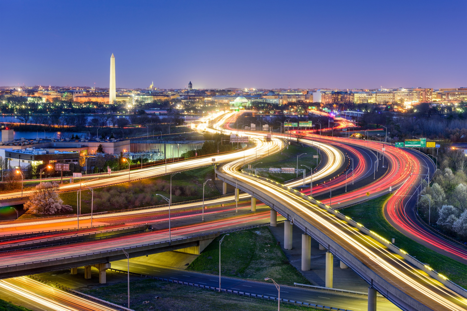 Washington, DC skyline at dusk with the Washington Monument and highway light trails